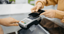 a person is using a credit card machine to make a payment