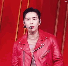 a man is wearing a red leather jacket and a microphone