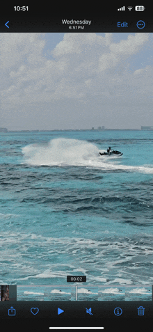 a phone screen shows a video of a jet ski in the ocean on wednesday