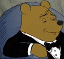 winnie the pooh is wearing a tuxedo and bow tie while sitting in a chair .