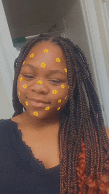 a woman with braids has yellow flowers painted on her face .