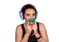 a woman wearing headphones and holding a fake mustache in front of her mouth