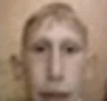 a blurry picture of a man 's face with a very strange look on his face .