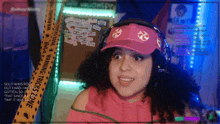 a woman wearing headphones and a pink hat with a candy on it