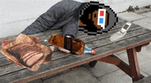 a person laying on a wooden bench with a bottle of black label whiskey and a cell phone