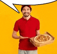 a man in a red shirt is holding a tray of pizza .