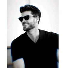 a black and white photo of a man wearing sunglasses and a black shirt