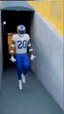 a football player with the number 20 on his jersey is running down a hallway