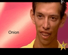 a man with a yellow shirt on is smiling in front of a pink background with the word onion written on it .