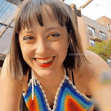 a woman wearing a colorful crocheted top smiles for the camera with the words " dinomite twins " below her