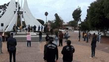 a group of people are gathered in a park and one of them is wearing a shirt that says " love over everything "