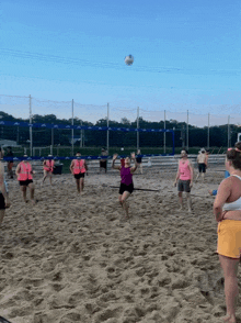 a group of women are playing volleyball on a beach