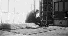 a black and white photo of two people sitting on a bed in front of a beverly hills polo club chest