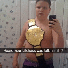 a young boy is taking a selfie with a championship belt around his neck .