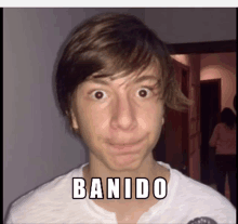 a young boy making a funny face with the words banido written on his face