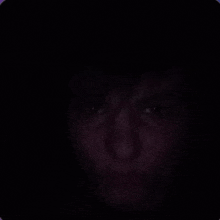 a person 's face is visible in the dark