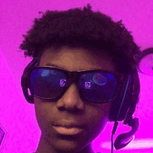 a young man wearing sunglasses and headphones against a purple background .