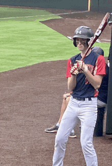 a baseball player wearing a helmet with the number 9 on it holds a bat