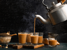 tea is being poured into a glass from a kettle