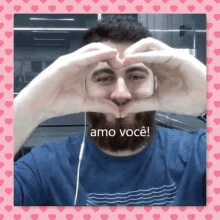 a man with a beard is making a heart shape with his hands and the words amo você written below him