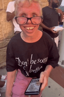 a man wearing glasses and a black shirt that says " don 't be sorry "