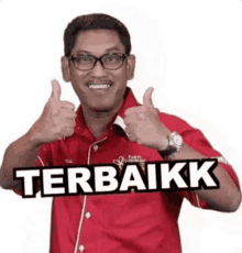 a man wearing glasses and a red shirt is giving a thumbs up with the word terbaikk behind him