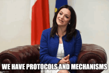 a woman in a blue jacket sits in a chair with the words we have protocols and mechanisms below her