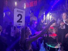 a round 2 sign hangs from the ceiling of a night club