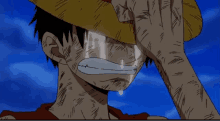 a man with a straw hat is crying with tears running down his face