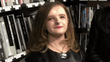 a woman is standing in front of a bookshelf with a book titled ' a woman 's journey ' on it