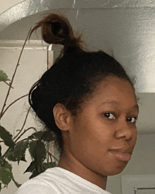 a woman with her hair in a bun and a white shirt