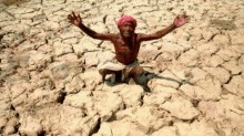 a man is sitting on the ground with his arms outstretched in a dry area .