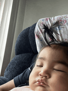 a baby is sleeping on a couch with a pillow on her head