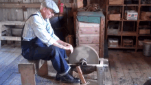 a man is sharpening a piece of metal in a room with a box that says ' i. ' on it