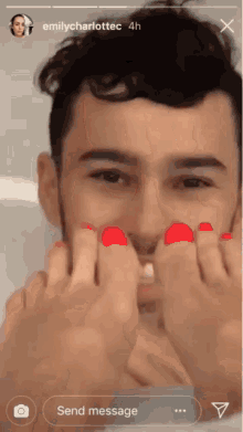 a man with red toenails is being tickled by a woman 's feet