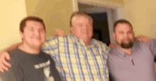 three men are posing for a picture and one of them is wearing a shirt that says ' i love you '