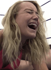 a woman is laughing with her mouth wide open