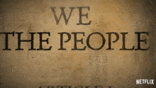 a sign that says " we the people " on a brown background