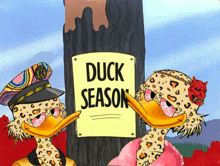 a couple of duck characters standing next to a sign that says duck season