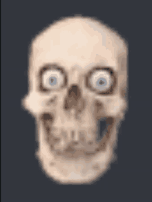 a blurry picture of a skull with blue eyes on a dark background .