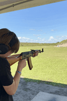 a person wearing headphones is holding a rifle