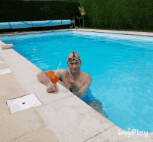 a man in a swimming pool holding a drink with a straw