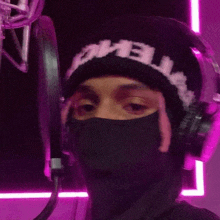 a person wearing a mask and headphones with a beanie that says " hell " on it