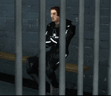 a man in a black suit is sitting on a bench behind bars with the letter e on his chest