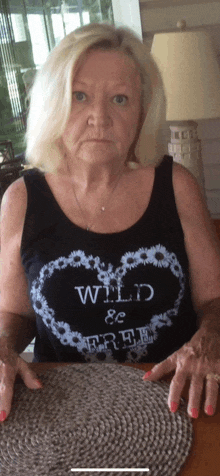 a woman is wearing a black tank top that says wild & free