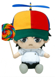 a stuffed toy wearing a colorful hat holds a rainbow lollipop