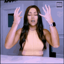 a woman is wearing a diva watch and making a gesture with her hands