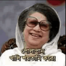 a woman wearing glasses and a scarf is smiling in a foreign language .