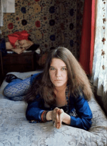 a woman is laying on a bed with her hands folded