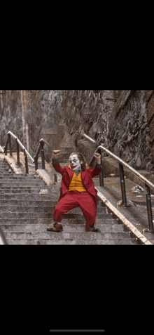 a clown is standing on a set of stairs .